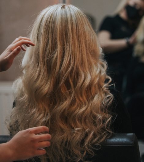 A blonde female getting a new hairstyle at a hair salon